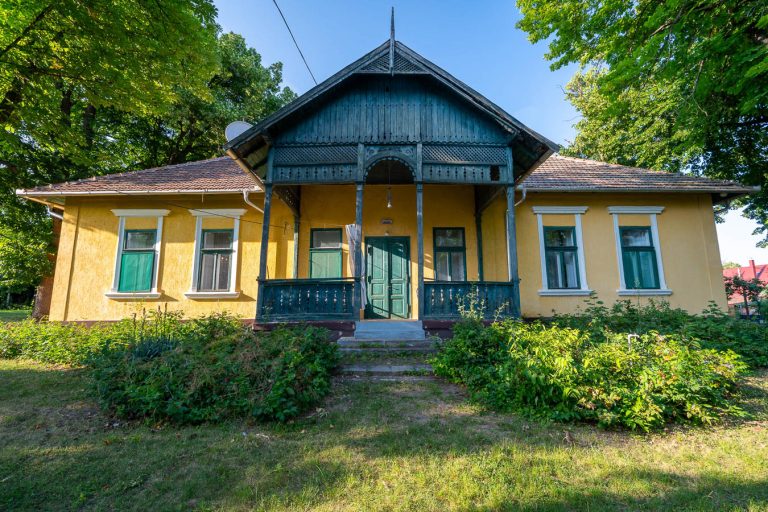 A kúria homlokzata a faragott, zöld faverandával
