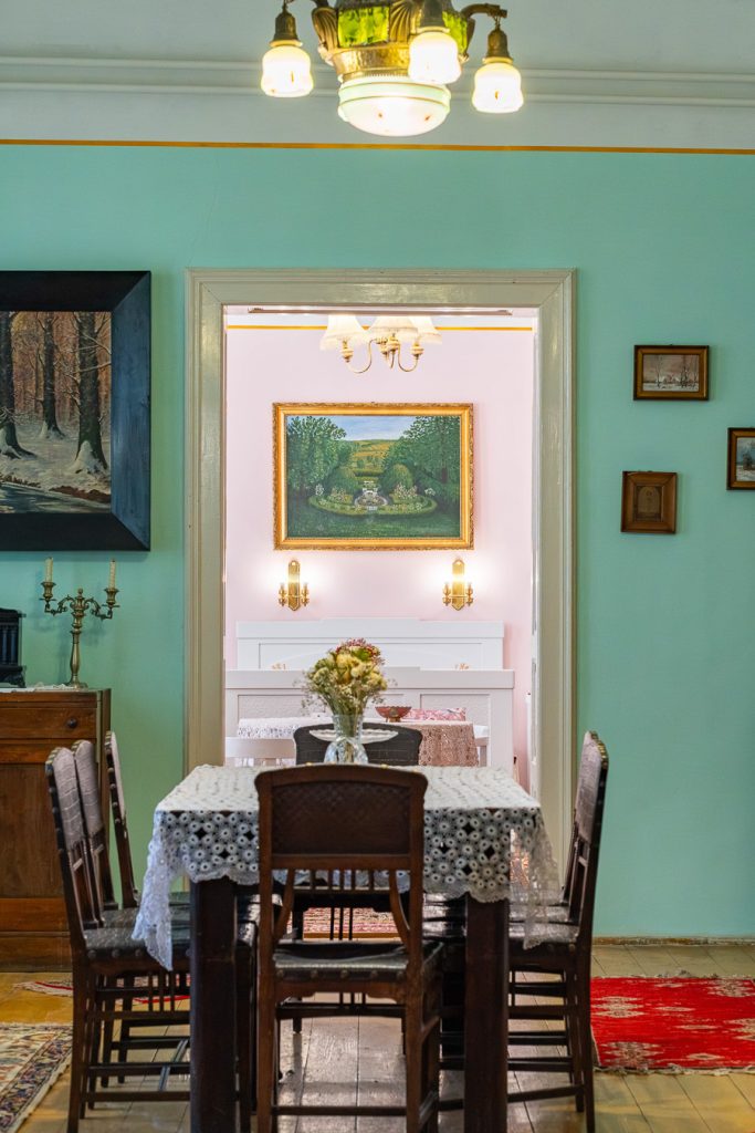 Menta színű étkező csipketerítős asztallal, mögötte a rózsaszín szoba